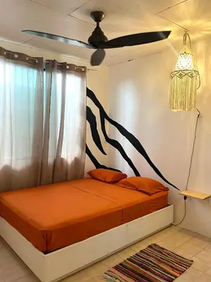 a bedroom with a bed with a painting on the wall at Casa bohio surf in Jacó