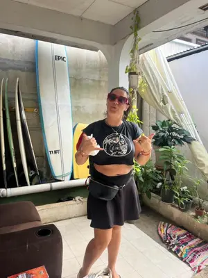 a pregnant woman standing in a room with surfboards at Casa bohio surf in Jacó