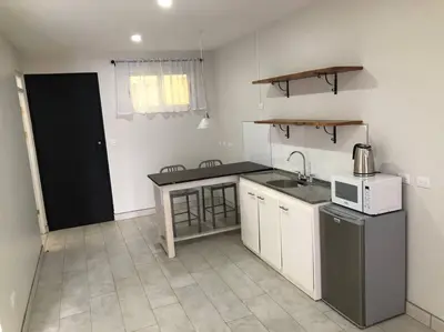a small kitchen with a sink and a microwave at Plaza Avenida Uno in Puntarenas
