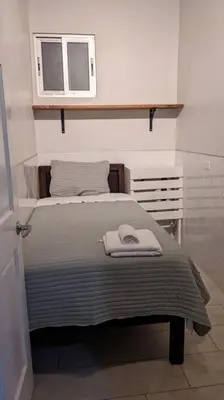 a small bedroom with a bed and a window at Plaza Avenida Uno in Puntarenas