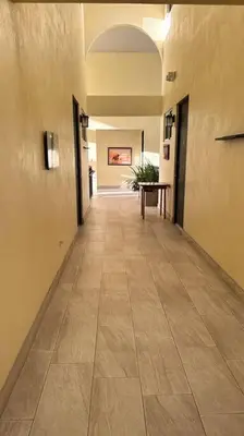an empty hallway in a building with a tile floor at Plaza Avenida Uno in Puntarenas
