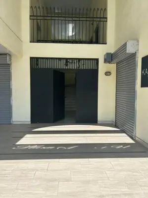 a building with two garage doors on the side of it at Plaza Avenida Uno in Puntarenas