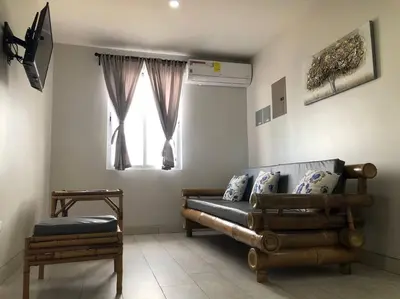 a living room with a couch and a window at Plaza Avenida Uno in Puntarenas