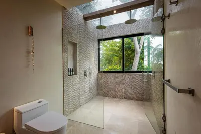 a bathroom with a toilet and a shower and a window at Villa Bahia Oceanview Designer Retreat Malpais in Mal País