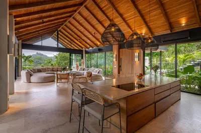 an open kitchen and living room with a table and chairs at Villa Bahia Oceanview Designer Retreat Malpais in Mal País