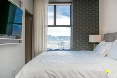a bedroom with a large white bed with a window at Escalante Executive Studio AC in San José