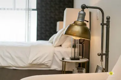a lamp sitting on a table next to a bed at Escalante Executive Studio AC in San José