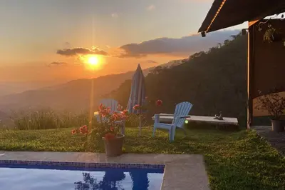 a pool with a bench and the sunset in the background at Agradable casa de Campo con Piscina privada in Escobal