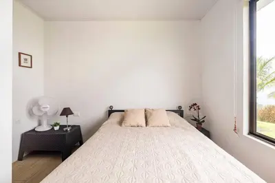 a white bedroom with a bed and a window at Agradable casa de Campo con Piscina privada in Escobal