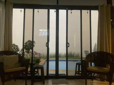 a living room with a view of a pool through a window at Agradable casa de Campo con Piscina privada in Escobal