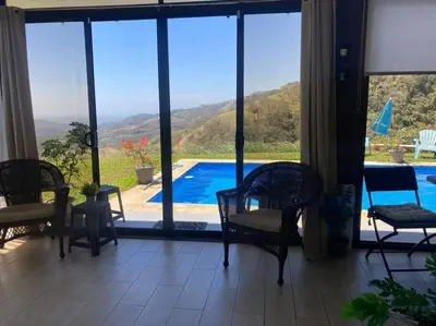 a room with chairs and a view of a swimming pool at Agradable casa de Campo con Piscina privada in Escobal