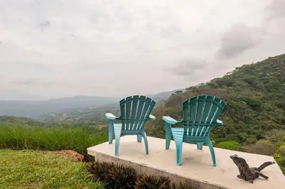two blue chairs on a ledge with a cat sitting between them at Agradable casa de Campo con Piscina privada in Escobal