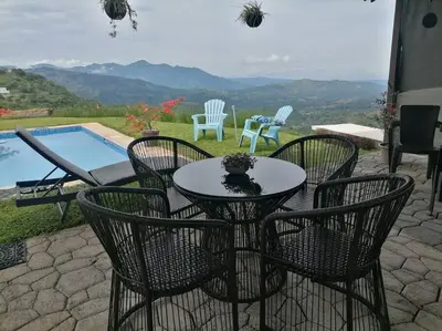 a table and chairs with a view of a pool at Agradable casa de Campo con Piscina privada in Escobal