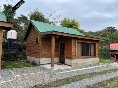 a small wooden cabin with a green roof at Cabaña La Finca in Cervantes