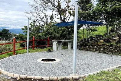 a blue umbrella sitting on top of a gravel circle at Cabaña La Finca in Cervantes