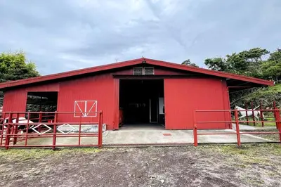 a red barn with a red fence in front of it at Cabaña La Finca in Cervantes