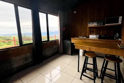 a kitchen with a counter and two bar stools at Cabaña La Finca in Cervantes