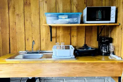 a kitchen counter with a sink and a microwave at Cabaña La Finca in Cervantes