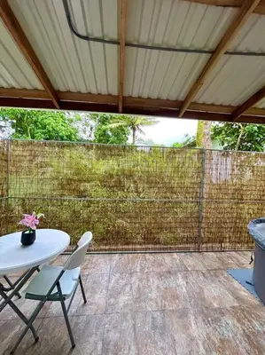 a patio with a table and chairs and a fence at Miravalles Tiny House in Upala