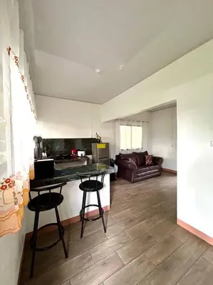 a living room with a table and two bar stools at Miravalles Tiny House in Upala