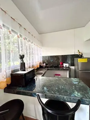 a kitchen with a counter and a counter top with chairs at Miravalles Tiny House in Upala