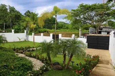 a garden with palm trees and a white fence at Casa Corales Dreams Deluxe in Playa Flamingo