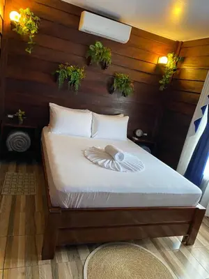 a bed in a room with plants on the wall at Sol y Luna Chalet in Fortuna