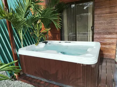 a jacuzzi tub sitting on a deck with plants at Sol y Luna Chalet in Fortuna