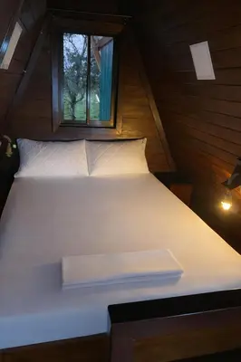 a white bed in a small room with a window at Sol y Luna Chalet in Fortuna