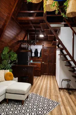 a living room with a staircase and a couch at Sol y Luna Chalet in Fortuna