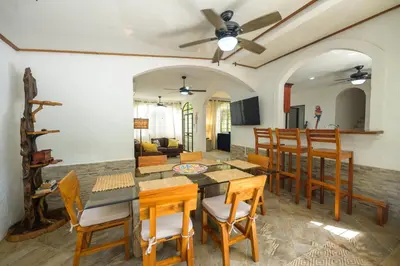 a dining room and living room with a table and chairs at Jungle & Beach Retreat Villa Tranquilo in Esterillos Este