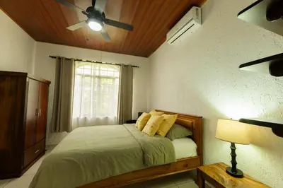 a bedroom with a bed with a ceiling fan at Jungle & Beach Retreat Villa Tranquilo in Esterillos Este