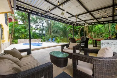 an outdoor patio with wicker furniture and a pergola at Jungle & Beach Retreat Villa Tranquilo in Esterillos Este