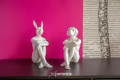 two white statues sitting on a table in front of a pink wall at Jungle at 24, City Views and Wonderland Vibes! in Hatillo