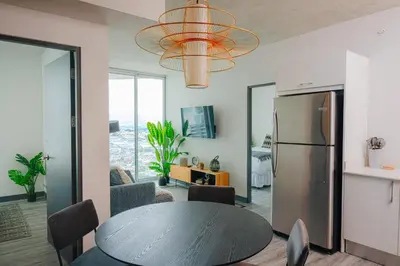 a kitchen and dining room with a table and a refrigerator at Jungle at 24, City Views and Wonderland Vibes! in Hatillo
