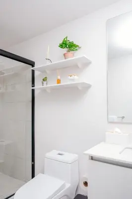 a white bathroom with a toilet and a sink at Jungle at 24, City Views and Wonderland Vibes! in Hatillo