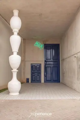 a white vase sitting in front of a blue door at Firefly at 29, City Views and Wonderland Vibes! in Hatillo