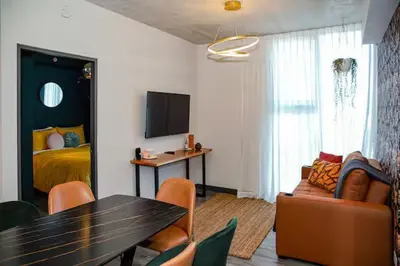 a living room with a dining table and a bedroom at Bloum at 22, City Views and Wonderland Vibes! in Hatillo