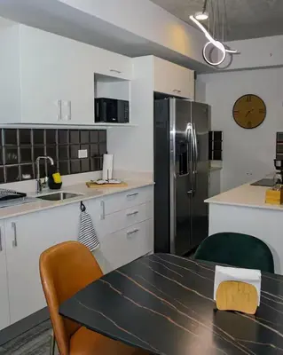 a kitchen with a table and a refrigerator at Bloum at 22, City Views and Wonderland Vibes! in Hatillo