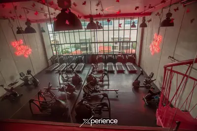a gym with rows of tread machines and red lights at Blue Nun at 29, City Views and Wonderland Vibes! in Hatillo