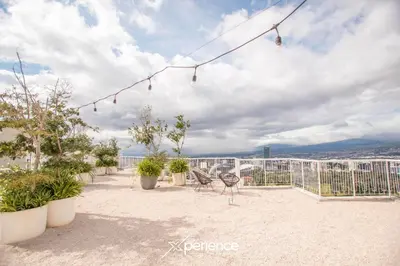 a balcony with chairs and plants on a building at Sunflower at 12, City Views and Wonderland Vibes! in Hatillo