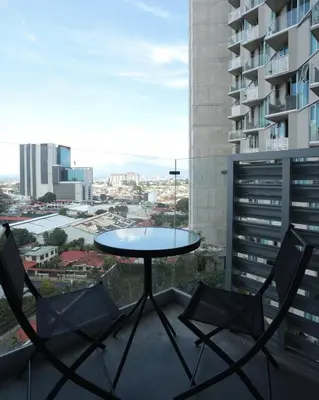 a table and chairs on the balcony of a building at Teal at 12, City Views and Wonderland Vibes! in Hatillo