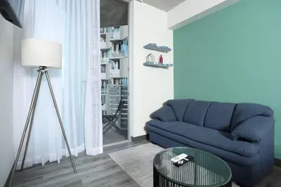 a living room with a blue couch and a table at Teal at 12, City Views and Wonderland Vibes! in Hatillo