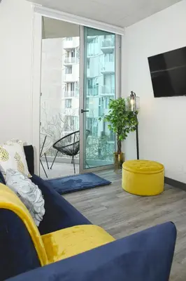 a living room with a yellow couch and a tv at Indigo at 11, City Views and Wonderland Vibes! in Hatillo