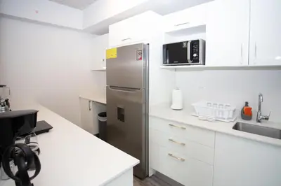a kitchen with a refrigerator and a sink at Gold Rabbit at 26, City Views and Wonderland Vibes! in Hatillo