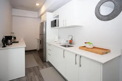 a white kitchen with a sink and a refrigerator at Gold Rabbit at 26, City Views and Wonderland Vibes! in Hatillo