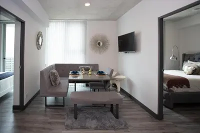 a living room with a table and a bed at Gold Rabbit at 26, City Views and Wonderland Vibes! in Hatillo
