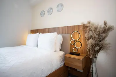 a bedroom with a bed and two mirrors on the wall at Serenitas at 20, City Views and Wonderland Vibes! in Hatillo