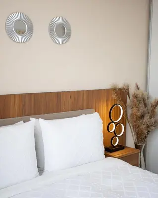 a bedroom with a white bed with a wooden headboard at Serenitas at 20, City Views and Wonderland Vibes! in Hatillo