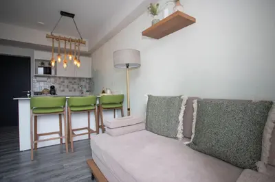a living room with a couch and a kitchen at Serenitas at 20, City Views and Wonderland Vibes! in Hatillo